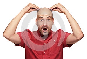 Shocked bald man holds his head. Isolated