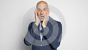 Shocked bald man looking at camera. Isolated