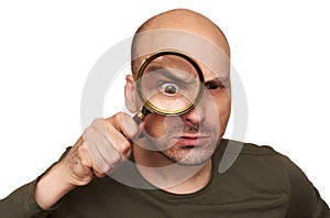Shocked bald man looking through magnifying glass