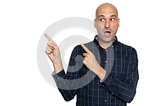 Shocked bald man pointing fingers aside. Isolated