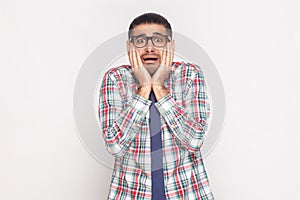 Shocked bearded businessman in colorful checkered shirt, blue ti