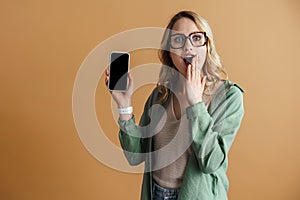 Shocked beautiful woman exclaiming while showing mobile phone