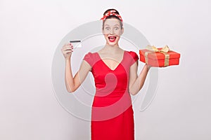 Shocked beautiful wonder woman, holding credit card, gift box.