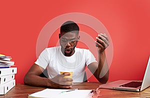 Shocked black guy look at empty cup with surprise