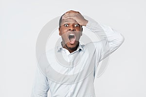 Shocked black male says wow, looks bugged eyes and rounded mouth, being amazed