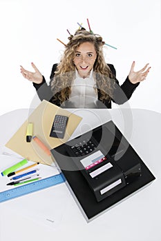 Shocked bookkeeper with open arms and pens in her hair