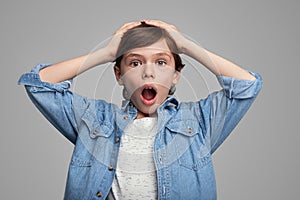 Shocked boy with hands on head