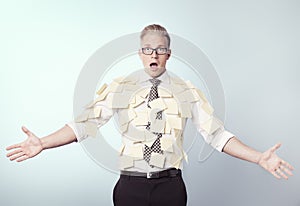 Shocked businessman covered by blank post-it notes.