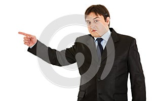 Shocked businessman pointing finger in corner