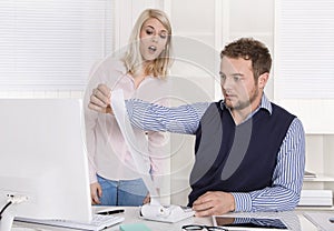 Shocked businessman sitting at desk controlling expenses and out
