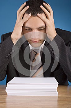 Shocked businessman at the stack of documents