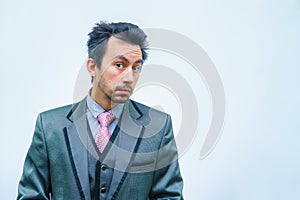 Shocked businessman with tousled hair looks into the camera.