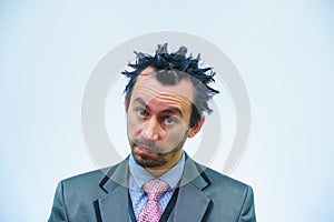 Shocked businessman with tousled hair looks into the camera.