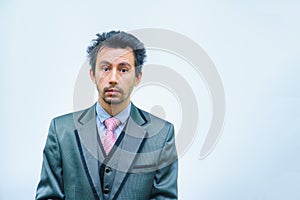 Shocked businessman with tousled hair looks into the camera.