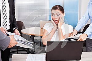 Shocked businesswoman looking at folders