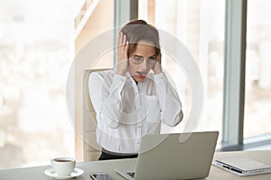 Shocked businesswoman looking at laptop screen