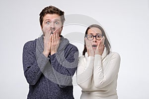Shocked caucasian mature man and woman screaming and touching face