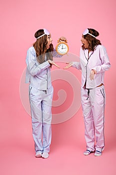 Shocked confused screaming friends women holding alarm clock