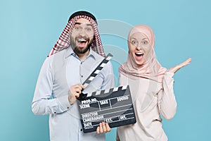 Shocked couple friends arabian muslim man wonam in keffiyeh kafiya ring igal agal hijab clothes isolated on blue wall