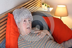 Shocked and dramatic senior woman in bed