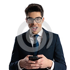 shocked elegant man with glasses scrolling on social media and finding the news