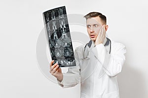 Shocked handsome young doctor man holds x-ray radiographic image ct scan mri isolated on white background. Male doctor