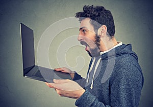 Shocked happy man watching new laptop