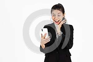 Shocked happy young Asian business woman in suit looking at mobile smart phone over white isolated background