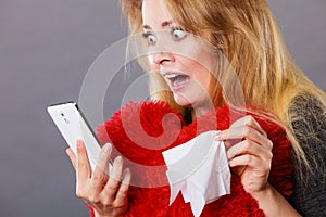 Shocked heartbroken woman looking at her phone