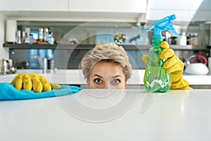 Shocked housewife cleaning near table