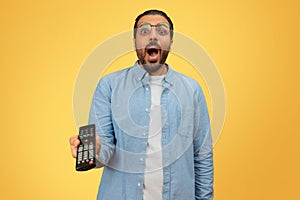 Shocked indian man with a remote control