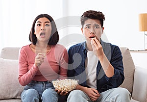 Shocked Korean Couple Watching TV Movie Sitting In Living Room