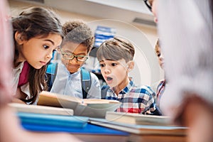 shocked little children looking at book