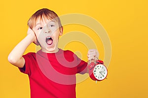 Shocked little student. Screaming boy with alarm clock. Seasonal discounts, sale concept. Mock up copy space. Retro clock in a