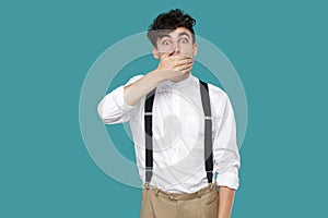 Shocked man covering his mouth, looking at camera with big eyes