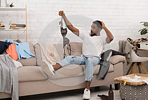 Shocked man holding woman`s bra on after house party