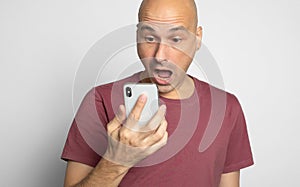 Shocked man looking at his smartphone