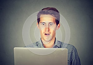 Shocked man looking at laptop