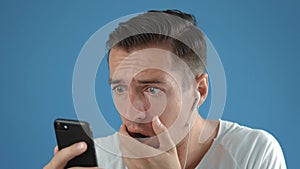 Shocked Man in Reacting message on Smartphone. Unpleasantly Surprised and Scared. Male is shocked by what he saw on his