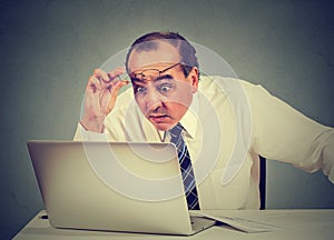 Shocked man reading message on computer in office