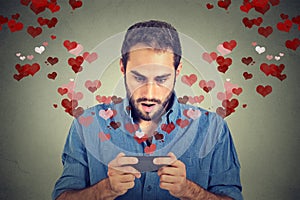 Shocked man sending receiving love sms text message on mobile phone