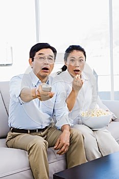 Shocked man and woman at home on couch