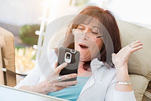Shocked Middle Aged Woman Gasps While Using Her Smart Phone