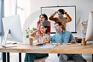 shocked multiracial business team working on project together