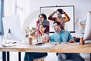 shocked multiracial business team working on project together