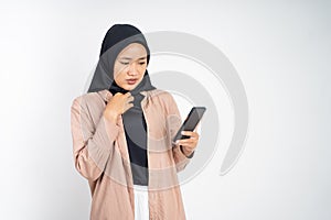 shocked muslim woman in hijab using a cell phone