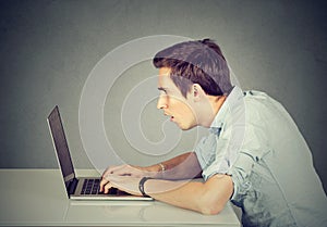 Shocked perplexed man sitting in front of laptop computer looking at screen