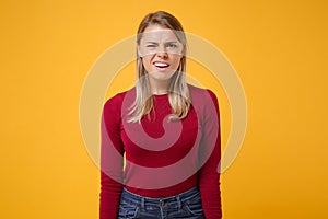 Shocked perplexed young blonde woman girl in casual clothes posing isolated on yellow orange wall background studio