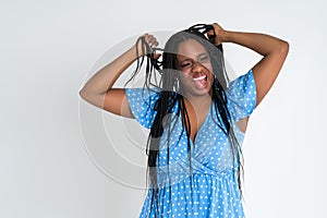 Shocked plus size model with wide open mouth on gray background, young African fat woman with curvy figure and pigtailed hairstyle