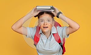 Shocked sad european teenager girl with backpack hold book on head, suffers from overwork and stress